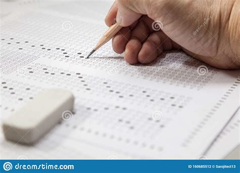 Students Hand Doing Exams Quiz Test Paper With Pencil Stock Photo