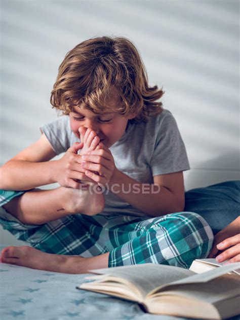 Boy Smelling Foot On Bed — Kid Leisure Stock Photo 205545930
