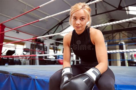 Portrait Of Female Boxer With Gum Shield In Gym Wearing Boxing Gloves