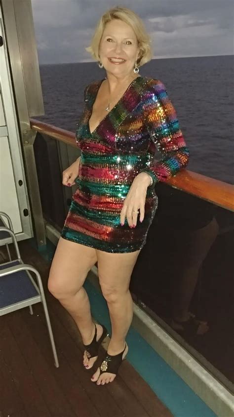A Woman Is Standing On The Deck Of A Cruise Ship Wearing A Colorful