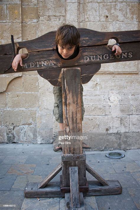 A Boy Trapped In A Medieval Torture Device Mdina Malta Stock Photo