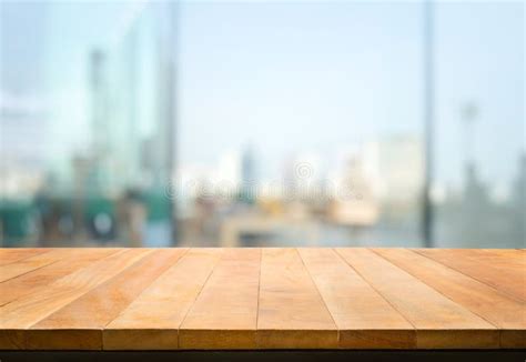 Wood Table Top On Blur Window Glasswall Background With City Viewfor