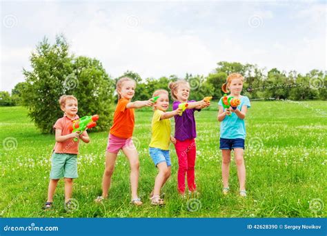 Kids Playing With Water Guns On A Meadow Stock Photo Image Of Guns