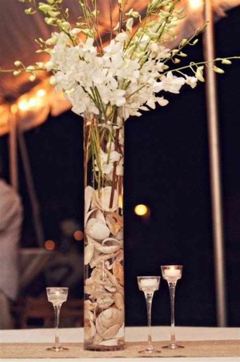 A beach wedding centerpiece of a seashell ball, seashells, candles and white orchids. 40 Amazing Beach Wedding Centerpieces | Weddingomania ...