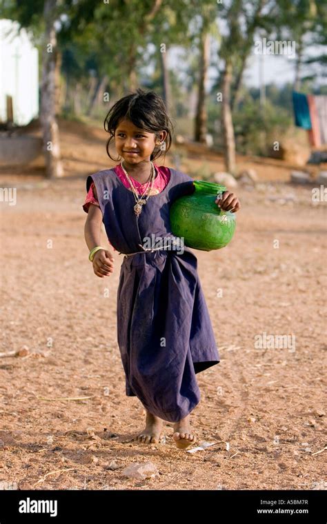 Young Poor Indian Girl Carrying Water Pot From A Village Water Tap