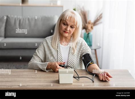 Senior Woman Measuring Blood Pressure At Home Stock Photo Alamy