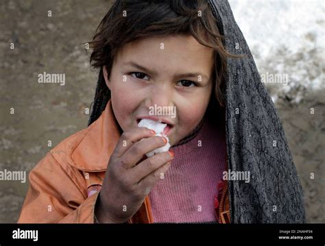 An Afghan Refugee Girl Looks On Camera As She Tastes Snow At A Refugee