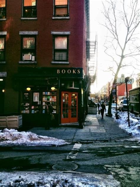People Are Walking Down The Sidewalk In Front Of Bookshops On A Snowy Day