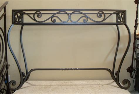 The base is black with gold accented wrought iron with floral medallions throughout the apron and long cabriole legs. Potter Art Metal Studios: Wrought Iron Console Table