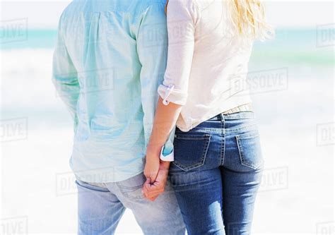 Man And Woman Holding Hands On Beach Stock Photo Dissolve