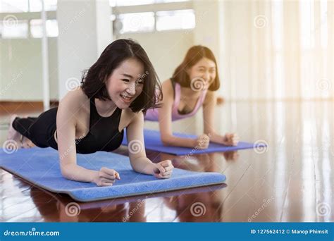 Two Young And Determined Beautifu Woman Planking In The Gym Basic Plank Exercise On Mats During