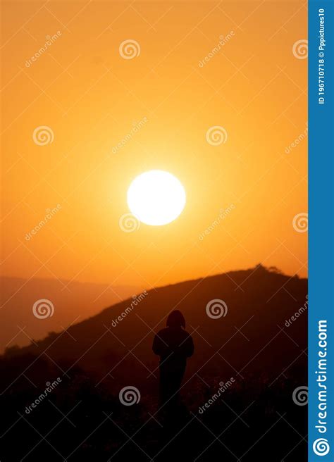 Man Is Standing And Watching Sunset At Mountainside Silhouette Stock