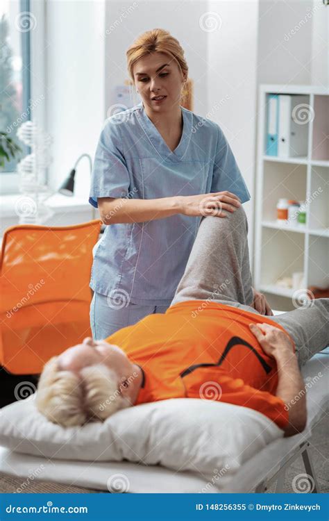 Professional Female Nurse Massaging Her Patients Leg Stock Image Image Of Hospital Light