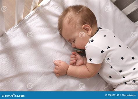 Adorable Baby With Pacifier Sleeping In Crib Above View Stock Image