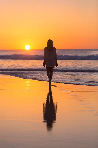 Lady Walking On Sandy Beach In Sunset Stock Photo Download Image Now