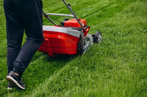 Man Cutting Grass With Lawn Mover In The Back Yard Free Photo