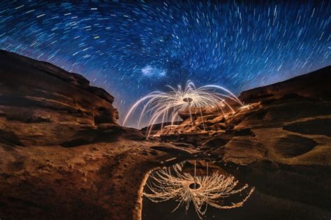 Premium Photo Burning Steel Wool On The Rock With Milky Way Near The