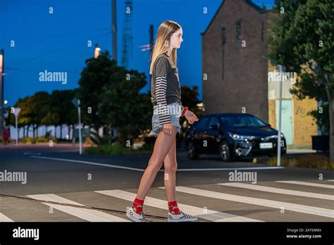 Tall Teenage Girl Crossing Street On Pedestrian Crossing In Auckland