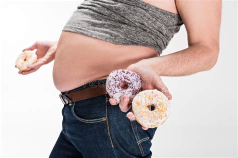 View Of Overweight Man Showing Belly And Holding Donuts Isolated On