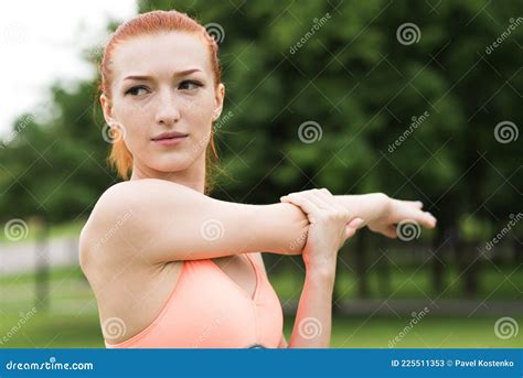 attractive redhead girl stretching her arm and shoulder in the park stock image image of