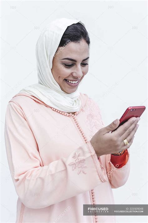 Smiling Moroccan Woman With Hijab And Typical Arabic Dress Using Mobile