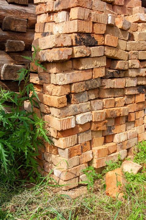 Pile Of Old Bricks In The Grass By The Log Wall Stock Image Image Of