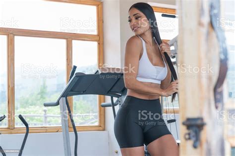 Beautiful Latin Woman Putting On Her Girdle To Take Care Of Her Body While At Home In Isolation