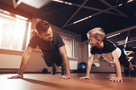 Father And Son Are Doing Push Ups In The Gym Premium Photo