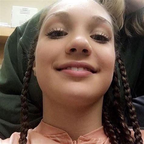 A Girl With Braids Is Smiling For The Camera