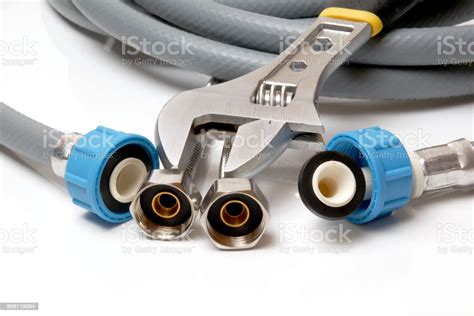 Closeup On Flexible Water Supply Tubes And Adjustable Wrench On White