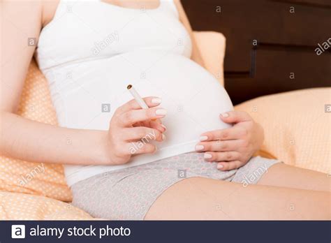 Pregnant Woman Smoking Cigarette At Home In Bed Stock Photo Alamy