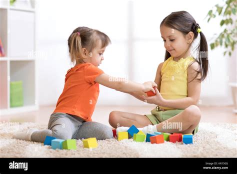 Cute Children Playing While Sitting On Carpet At Home Stock Photo Alamy