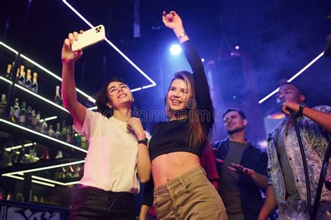 Two Women Making Selfie Group Of Friends Having Fun In The Night Club Together Stock Image