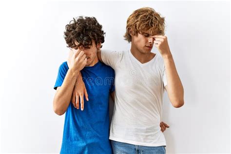 Young Gay Couple Standing Together Over Isolated Background Tired Rubbing Nose And Eyes Feeling