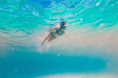 woman swimming with snorkel underwater at all inclusive caribbean resort white sand beach by