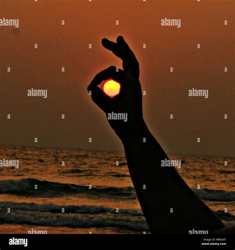 Optical Illusion Of Silhouette Hand Holding Sun Stock Photo Alamy