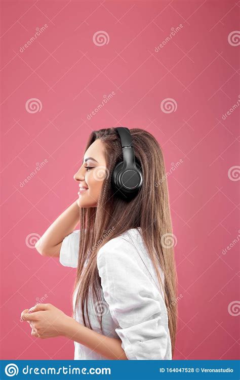 Beautiful Young Woman In Wireless Headphones Listening To Music And