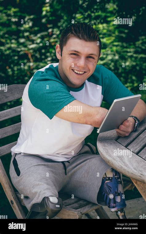 Quadriplegic Man Sitting In His Garden With A Digital Tablet He Is