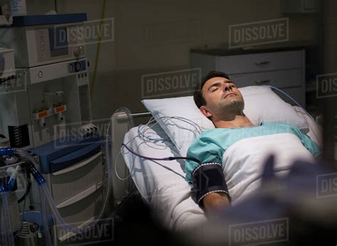 Male Patient Lying In Hospital Bed In Intensive Care Unit Stock Photo