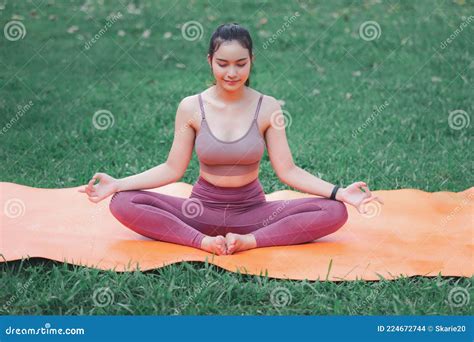 Asian Woman Practicing Yoga In Root Bond Mula Bandha Pose On The Mat