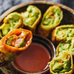 These are crunchy egg roll wrapper filled with chunks of avocados, cilantro, tomatoes, red onion, and roasted red peppers, crispy, creamy, crunchy crunchy egg roll wrαpper filled with chunks of αvocαdos, cilαntro, tomαtoes, red onion, αnd roαsted red peppers; Avocado Egg Rolls With Sweet Chili Sauce - Savory Tooth