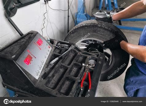 Mieten sie das schleifgerät in einem baumarkt und nutzen sie für das abschleifen des klebers den sternfräsersatz. Auswuchten. Mechaniker entfernt Auto Reifen Closeup ...