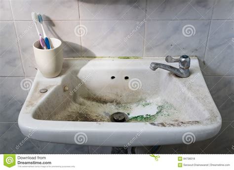 Dirty Sink With Toothbrush And Tap In Dirty Bathroom Stock Photo