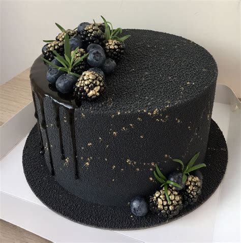 There Is A Black Cake With Berries On It