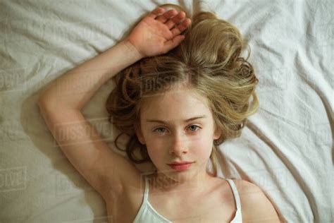 Serious Caucasian Girl Laying On Bed Stock Photo Dissolve