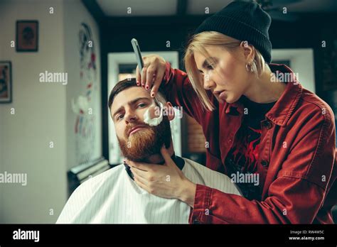 Client During Beard Shaving In Barbershop Female Barber At Salon