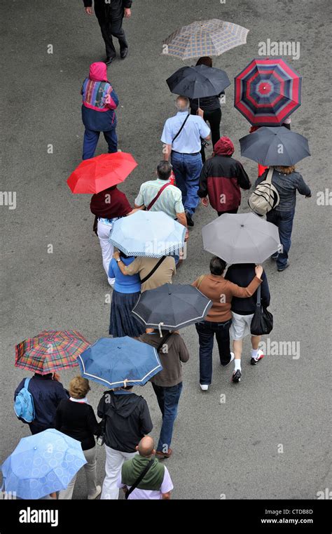 People With Umbrellas Walking In The Rain On A Rainy Wet Day In Summer