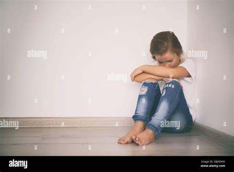 Scared Little Girl Sitting In Corner Domestic Violence Concept Stock