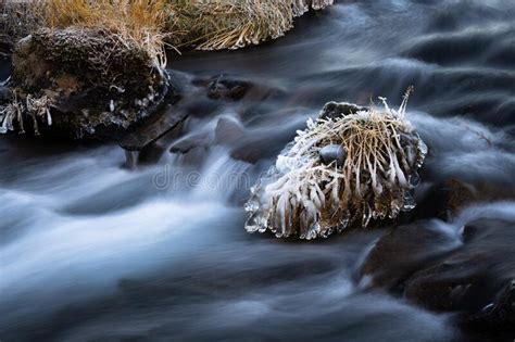 Freezing Cold Water Flowing Over Rocks With Ice And Frost At A Small