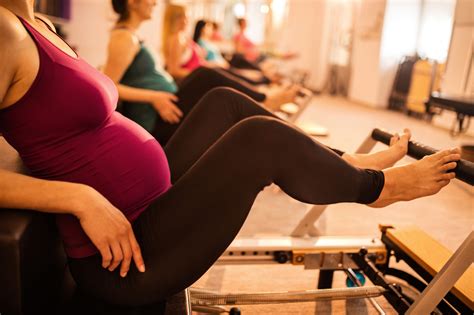 Unrecognizable Pregnant Woman Exercising During Pilates Class In Health